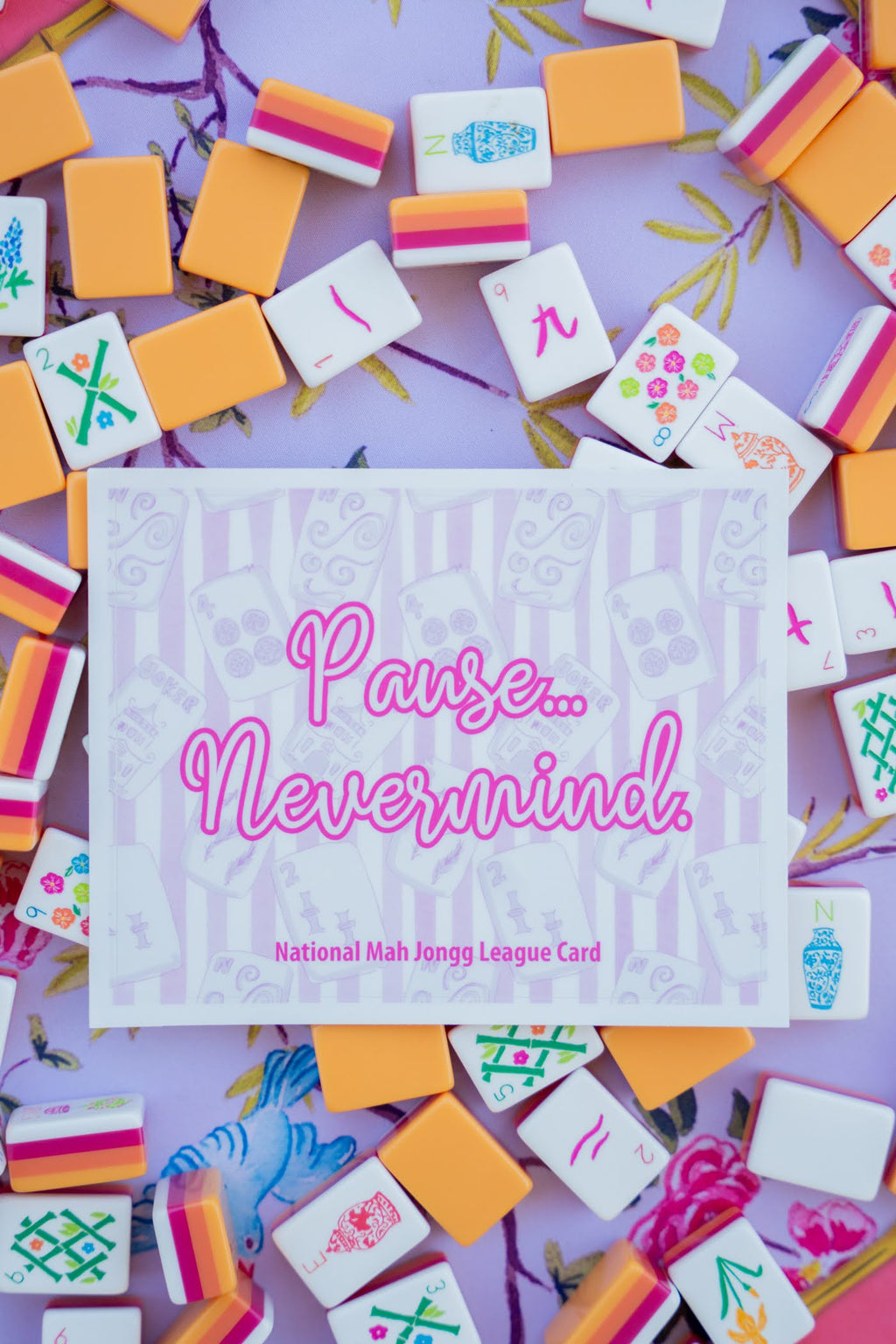 Card with 'Pause... Nevermind.' text surrounded by colorful Mah Jongg tiles on a purple background